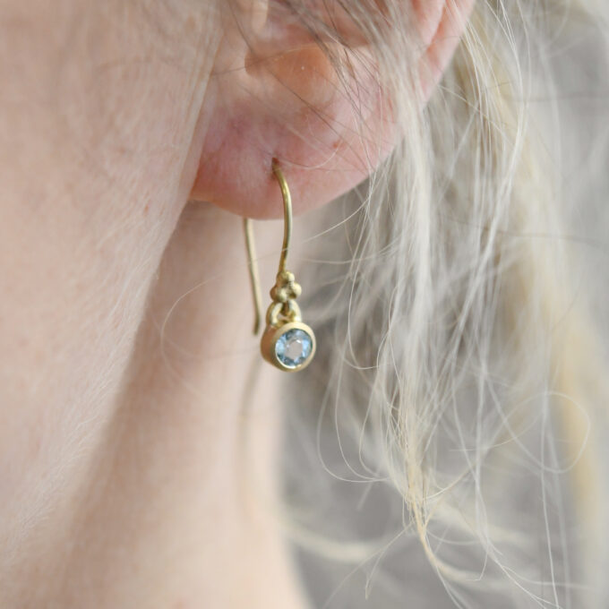Goldene Ohrringe mit leuchtendem Aquamarin